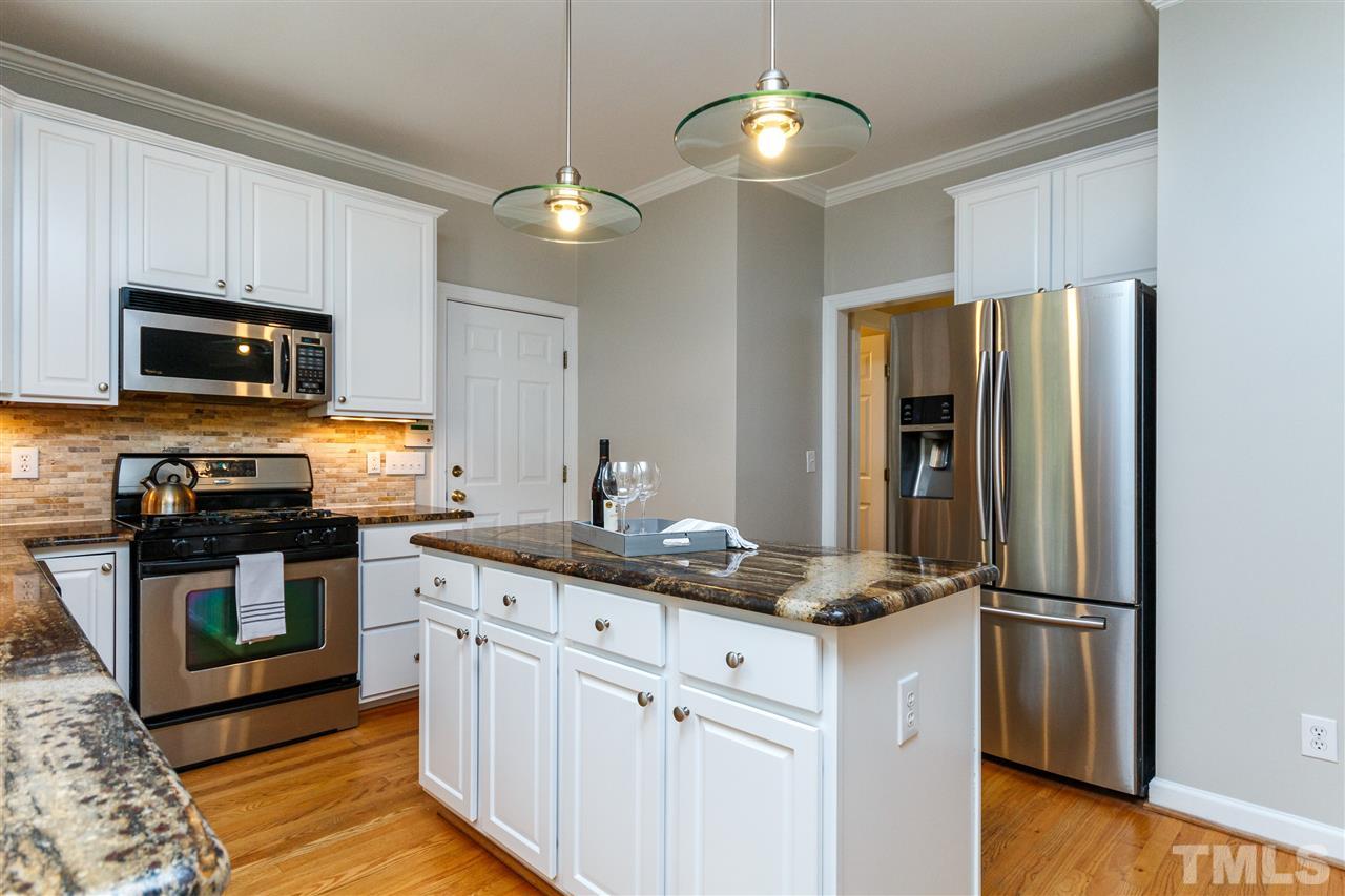 2936 Sunnystone Way Raleigh, NC 27613 - Photo 5 of 29 a kitchen with stainless steel appliances granite countertop a refrigerator a stove top oven a sink and dishwasher with wooden floor