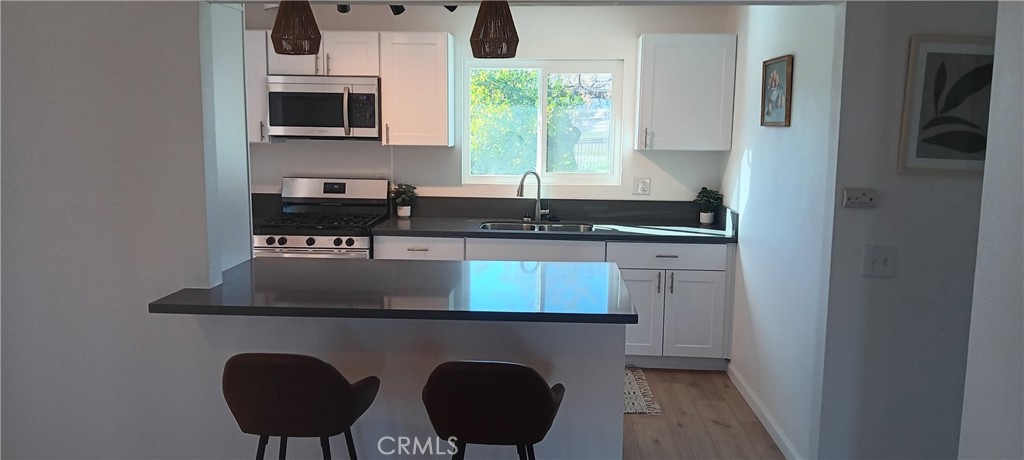 1022 Ruby Drive Perris, CA 92571 - Photo 8 of 27 a kitchen with stainless steel appliances granite countertop a stove a sink and a microwave