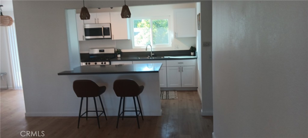 1022 Ruby Drive Perris, CA 92571 - Photo 9 of 27 a kitchen with stainless steel appliances granite countertop a sink and a microwave