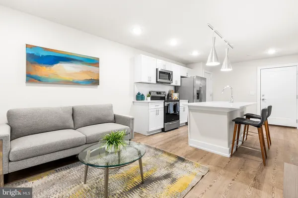 a living room with furniture a kitchen view and a dining table