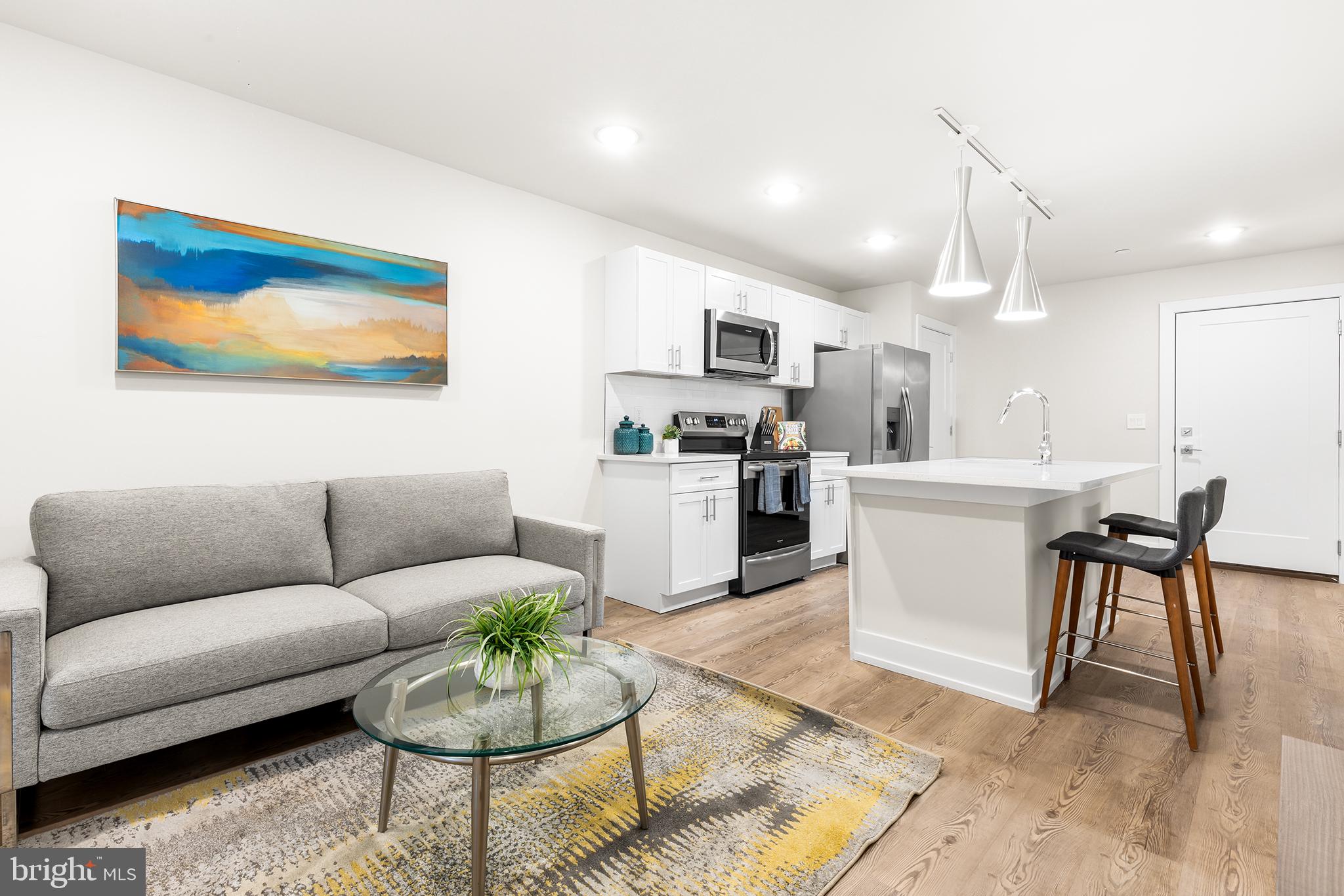214 Vine Street, Unit 104 Philadelphia, PA 19106 - Photo 1 of 35 a living room with furniture a kitchen view and a dining table