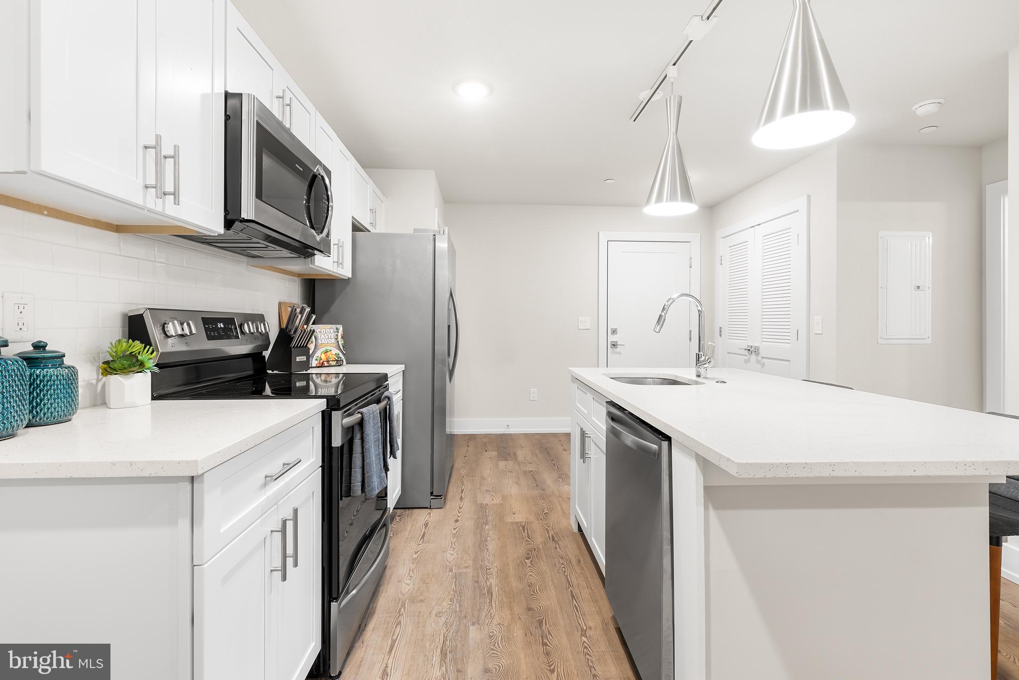 214 Vine Street, Unit 104 Philadelphia, PA 19106 - Photo 8 of 35 a kitchen with a sink a stove and cabinets