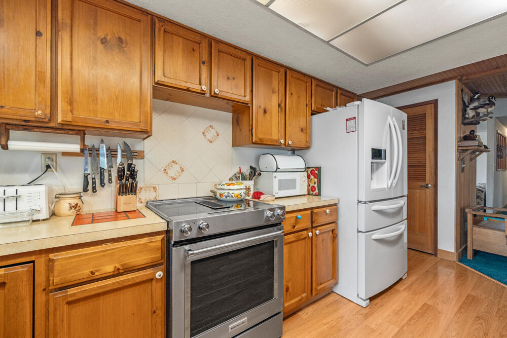 47477 Gerber Road Bonanza, OR 97623 - Photo 55 of 63 a kitchen with stainless steel appliances granite countertop a refrigerator a stove a sink dishwasher and white cabinets with wooden floor
