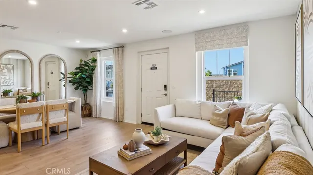 a living room with furniture a wooden floor and a large window