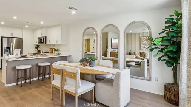 a living room with furniture a potted plant and kitchen view
