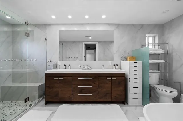 a bathroom with a sink a toilet and shower