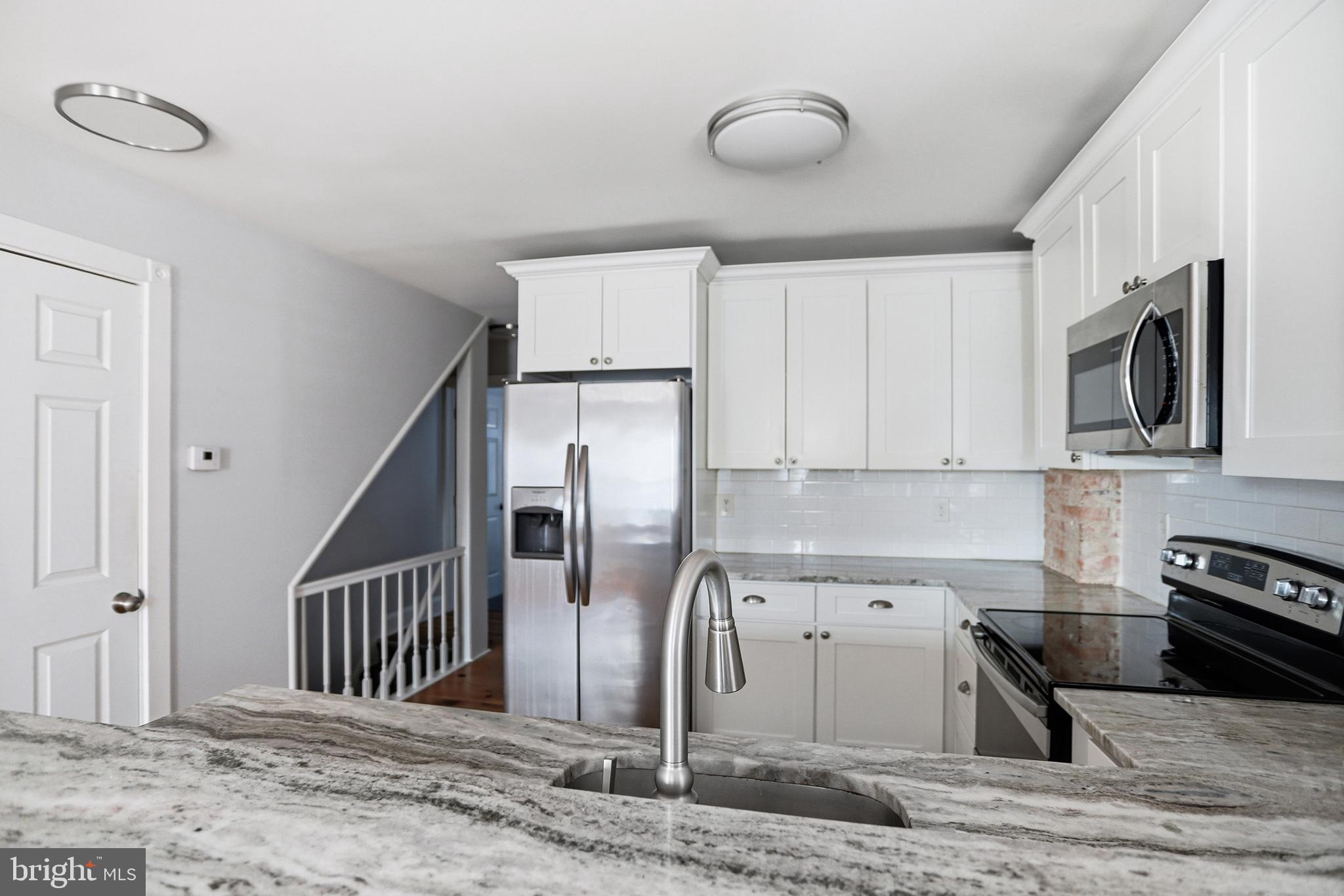 33 East Front Street Media, PA 19063 - Photo 5 of 11 a kitchen with stainless steel appliances granite countertop a refrigerator a stove a sink and a microwave