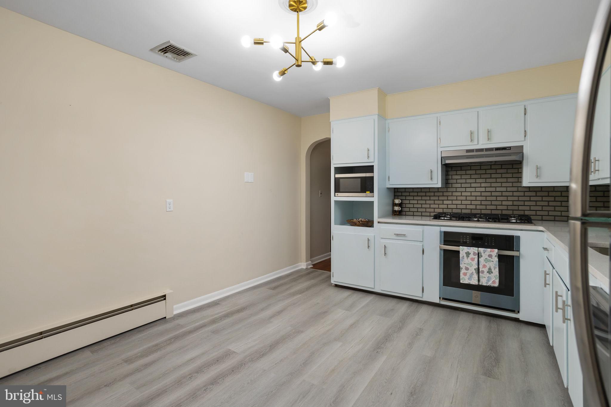 45 Cubberley Road West Windsor, NJ 08550 - Photo 12 of 37 a kitchen with stainless steel appliances a white stove top oven and a sink with wooden floor