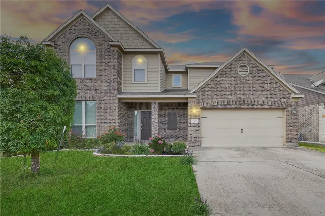 a front view of a house with a garden and plants