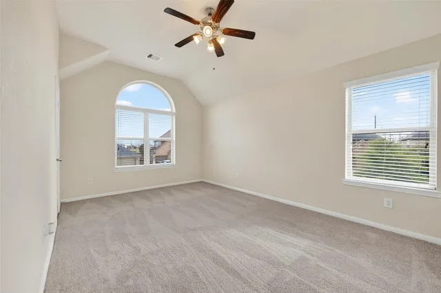 an empty room with windows and fan