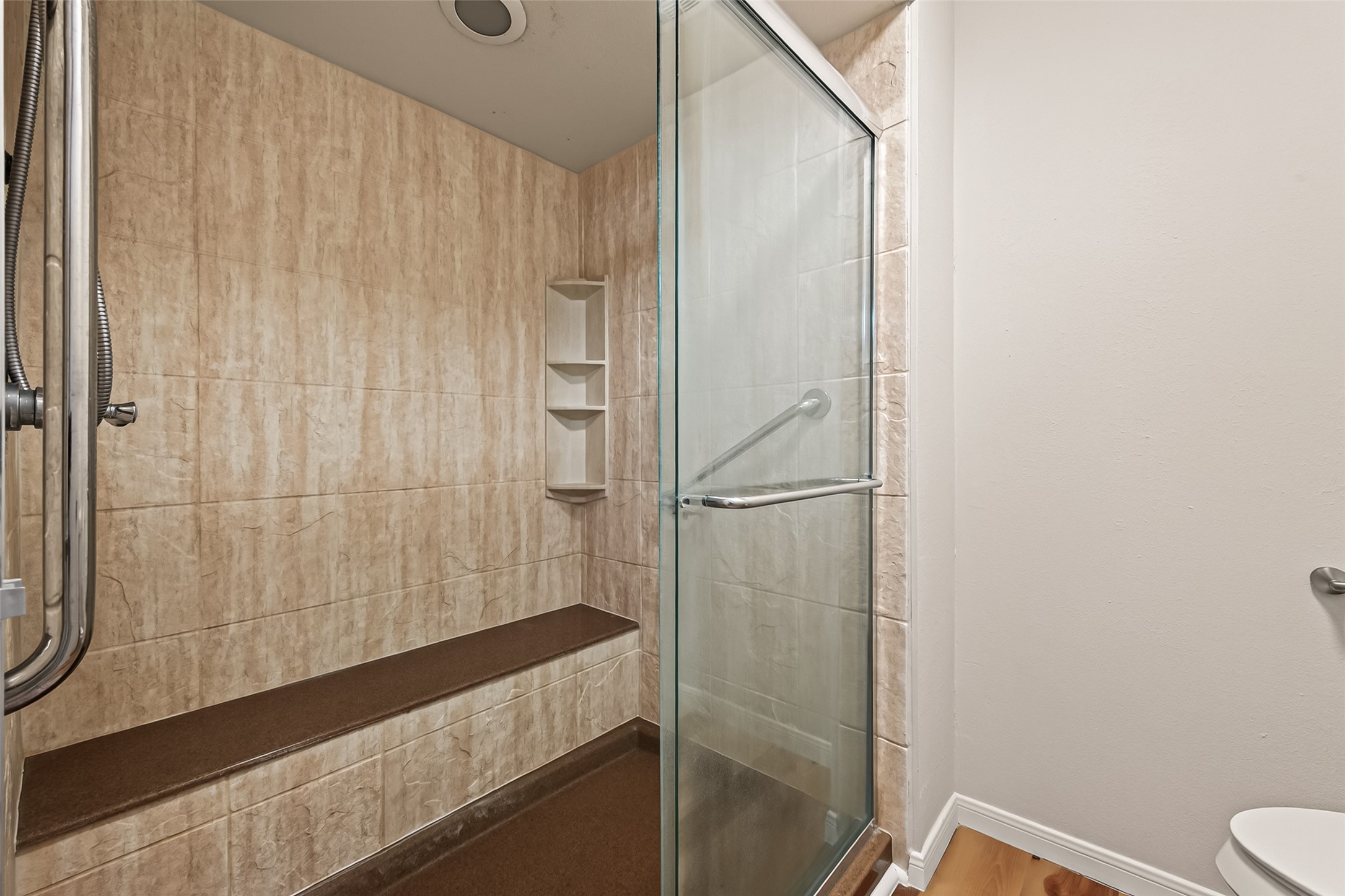 14737 Perthshire Road Houston, TX 77079 - Photo 20 of 22 Expansive primary bathroom featuring a luxurious walk-in shower with a convenient bench.