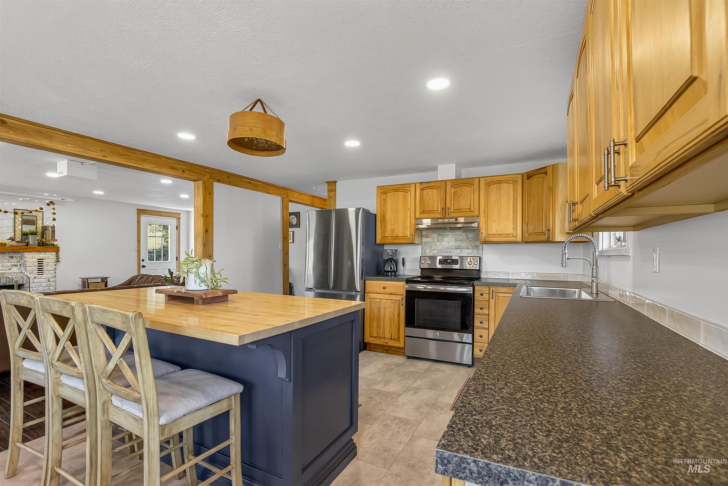 2157 Lukes Gulch Road Stites, ID 83552 - Photo 15 of 50 Kitchen featuring recessed lighting, stainless steel electric range oven, a breakfast bar, wood counters, and decorative backsplash