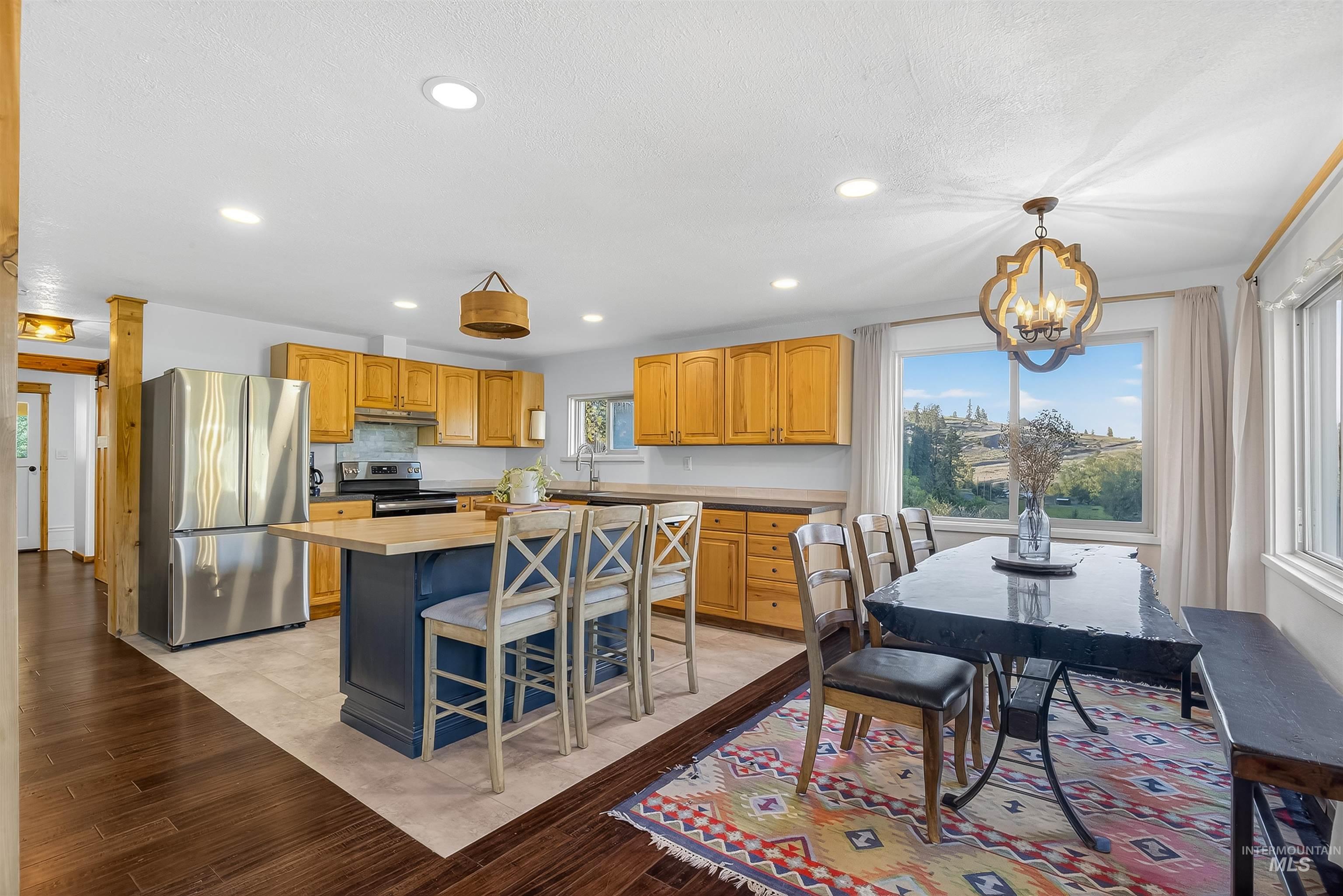 2157 Lukes Gulch Road Stites, ID 83552 - Photo 19 of 50 Kitchen featuring appliances with stainless steel finishes, a center island, light wood-type flooring, recessed lighting, and a chandelier
