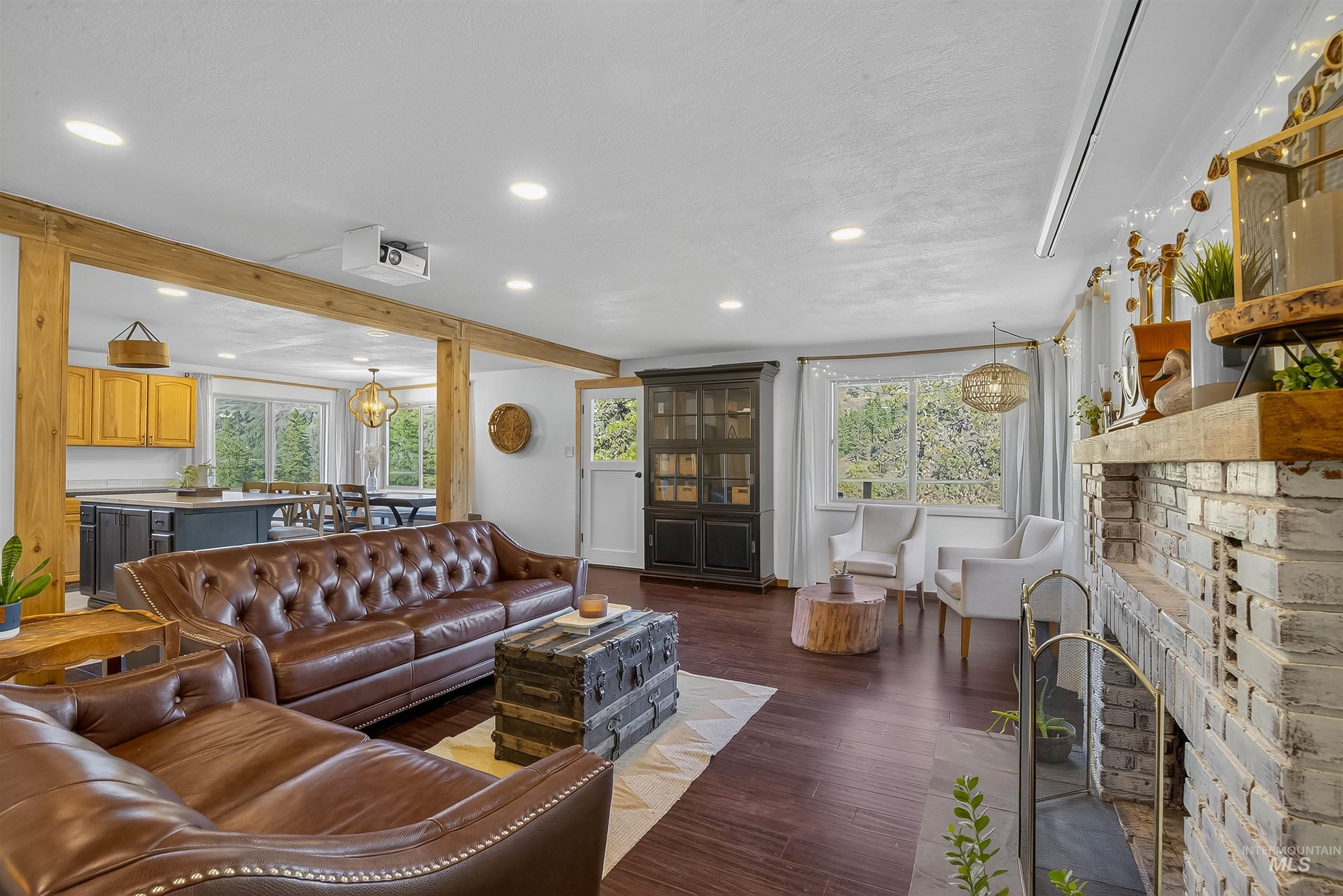 2157 Lukes Gulch Road Stites, ID 83552 - Photo 20 of 50 Living area featuring dark wood-type flooring, recessed lighting, a fireplace, beamed ceiling, and a chandelier