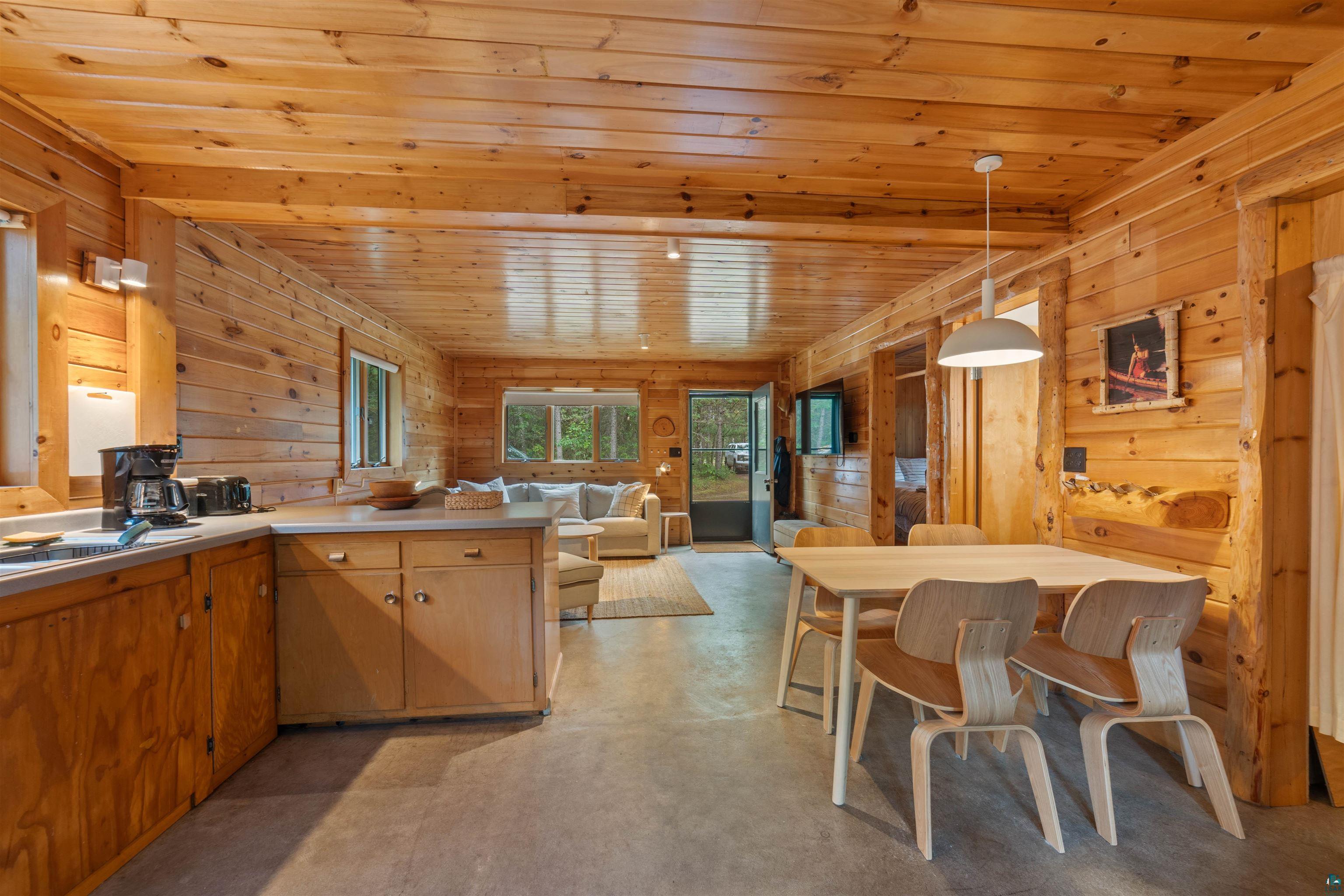 11321 East Town Line Road Solon Springs, WI 54873 - Photo 29 of 31 Kitchen featuring wood ceiling, finished concrete floors, open floor plan, wooden walls, and a peninsula