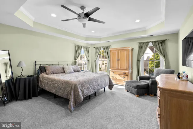 a spacious bedroom with a bed a couch and a large window