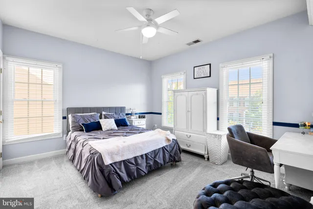 a bedroom with a bed couches and a flat tv screen