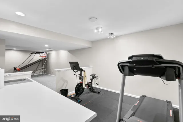 a room with gym equipment and wooden floor