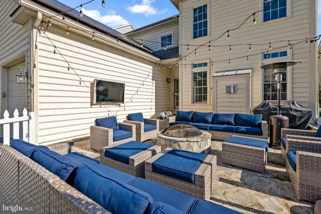 a view of a patio with couches and a dining table and chairs with wooden floor