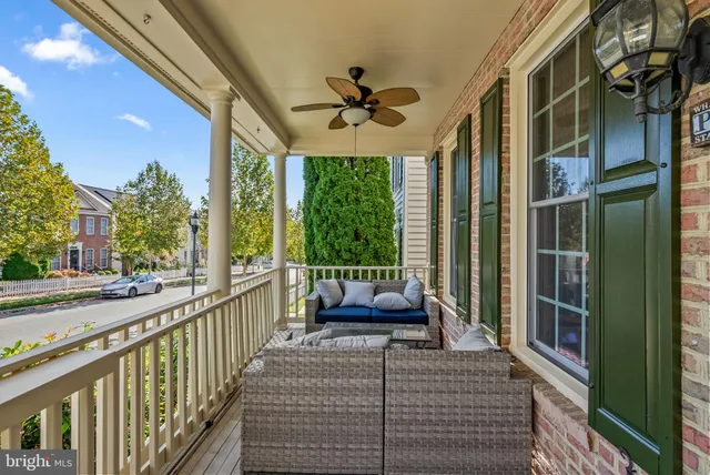 a view of a patio with couches potted plants and wooden floor