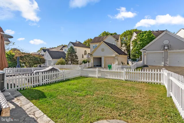 a view of a house with a small yard and wooden fence