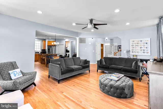a living room with furniture and a ceiling fan