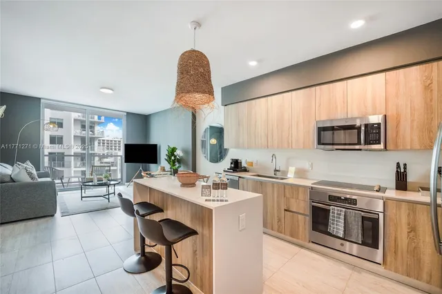 a kitchen with stainless steel appliances a stove a sink a microwave a refrigerator and cabinets