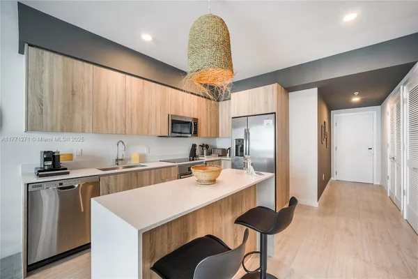 a kitchen with stainless steel appliances granite countertop a sink refrigerator and cabinets