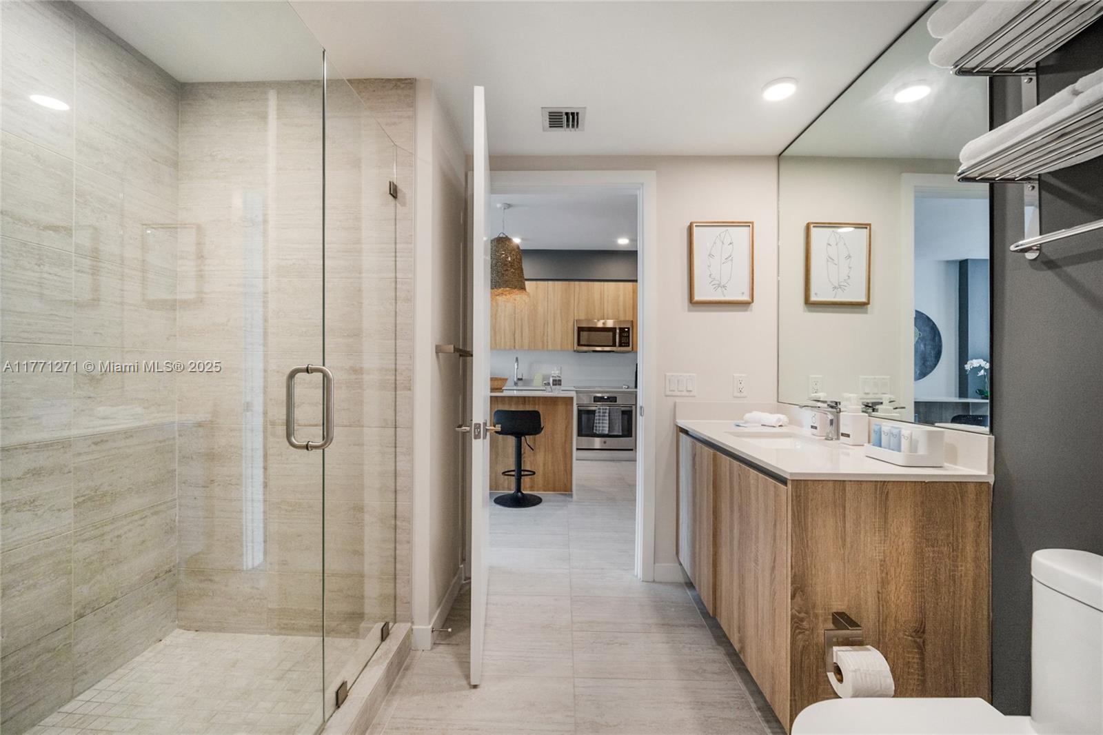 3900 Biscayne Boulevard, Unit S1016 Miami, FL 33137 - Photo 9 of 12 a bathroom with a double vanity sink mirror and shower