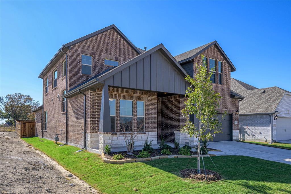 613 Brazos Drive Van Alstyne, TX 75495 - Photo 4 of 29 View of front of house with brick siding, a front yard, board and batten siding, and concrete driveway