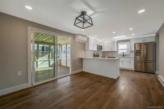 a view of kitchen with wooden floor and electronic appliances