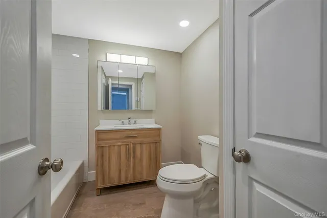 a bathroom with a granite countertop sink toilet and mirror