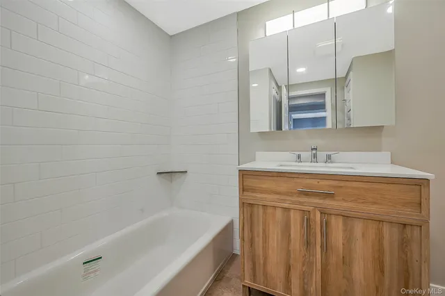 a bathroom with a bathtub a sink a vanity and a shower