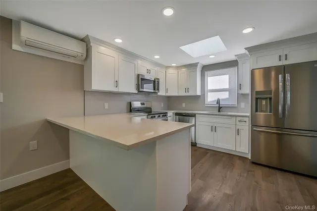 a kitchen with a refrigerator a sink and dishwasher with wooden floor