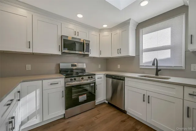 a kitchen with white cabinets and appliances