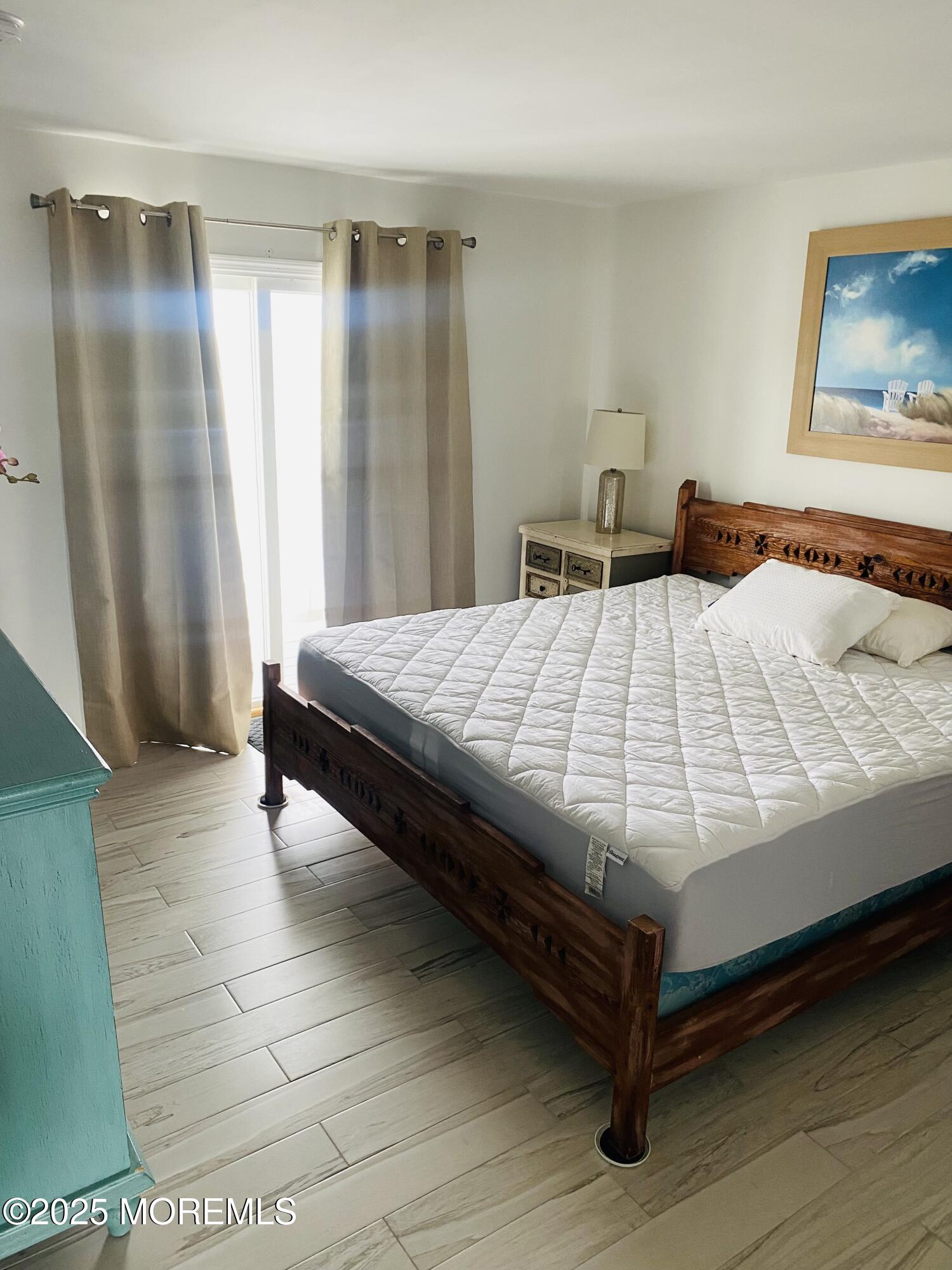 1 2nd Avenue, Unit 34 Seaside Heights, NJ 08751 - Photo 12 of 19 a bedroom with a bed and wooden floor