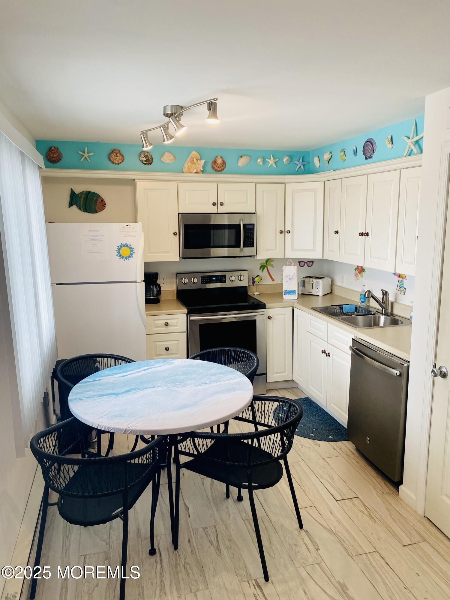 1 2nd Avenue, Unit 34 Seaside Heights, NJ 08751 - Photo 7 of 19 a kitchen with a table chairs and a stove