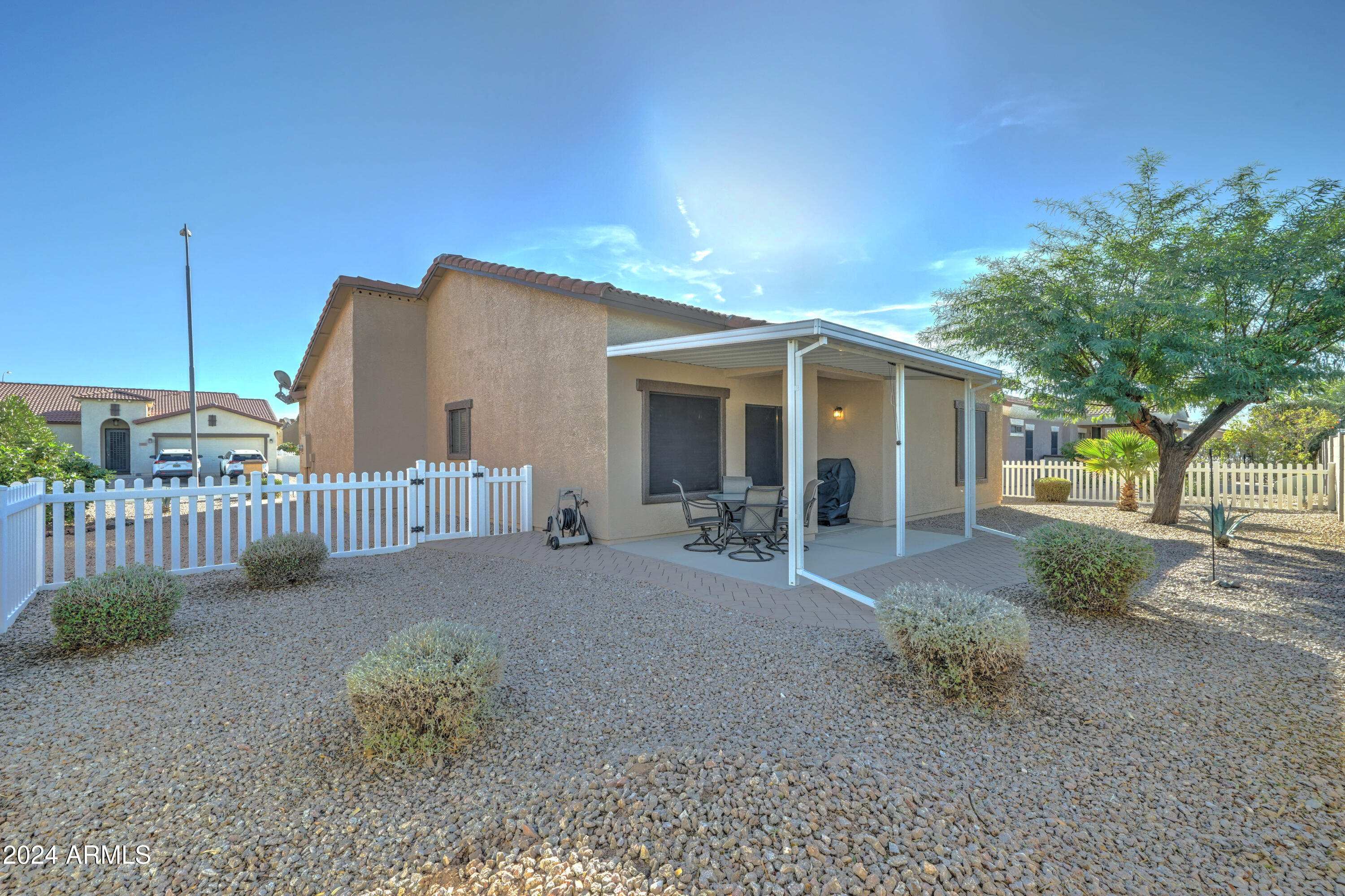 2101 South Meridian Road, Unit 131 Apache Junction, AZ 85120 - Photo 27 of 59 a view of a house with a small yard and a large tree