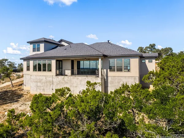 a front view of a house with a yard and mountain view in back
