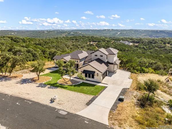 a view of a house with a yard and potted plants