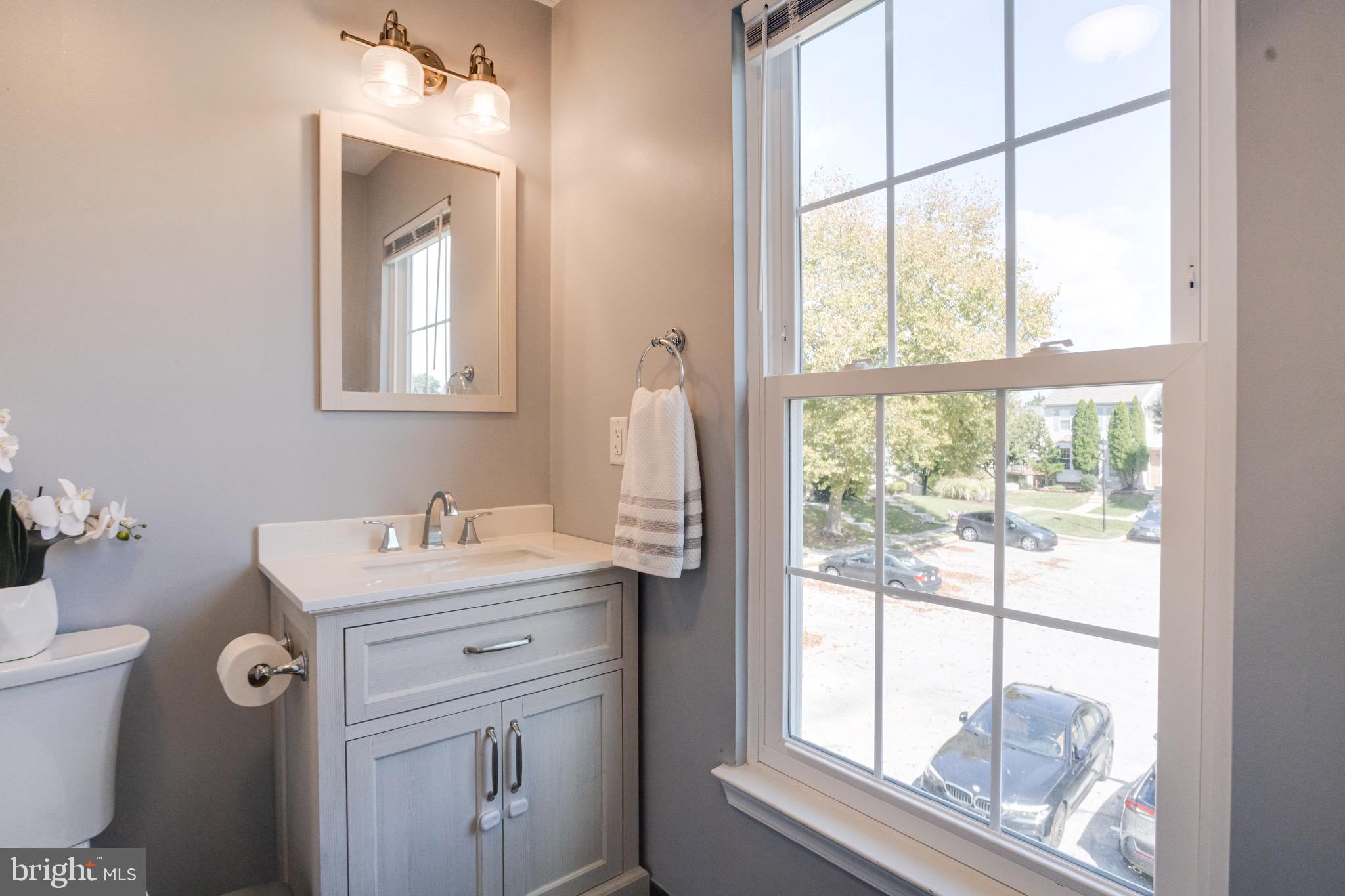 16 Sandview Court Baltimore, MD 21209 - Photo 29 of 58 a bathroom with a sink vanity granite toilet and a window