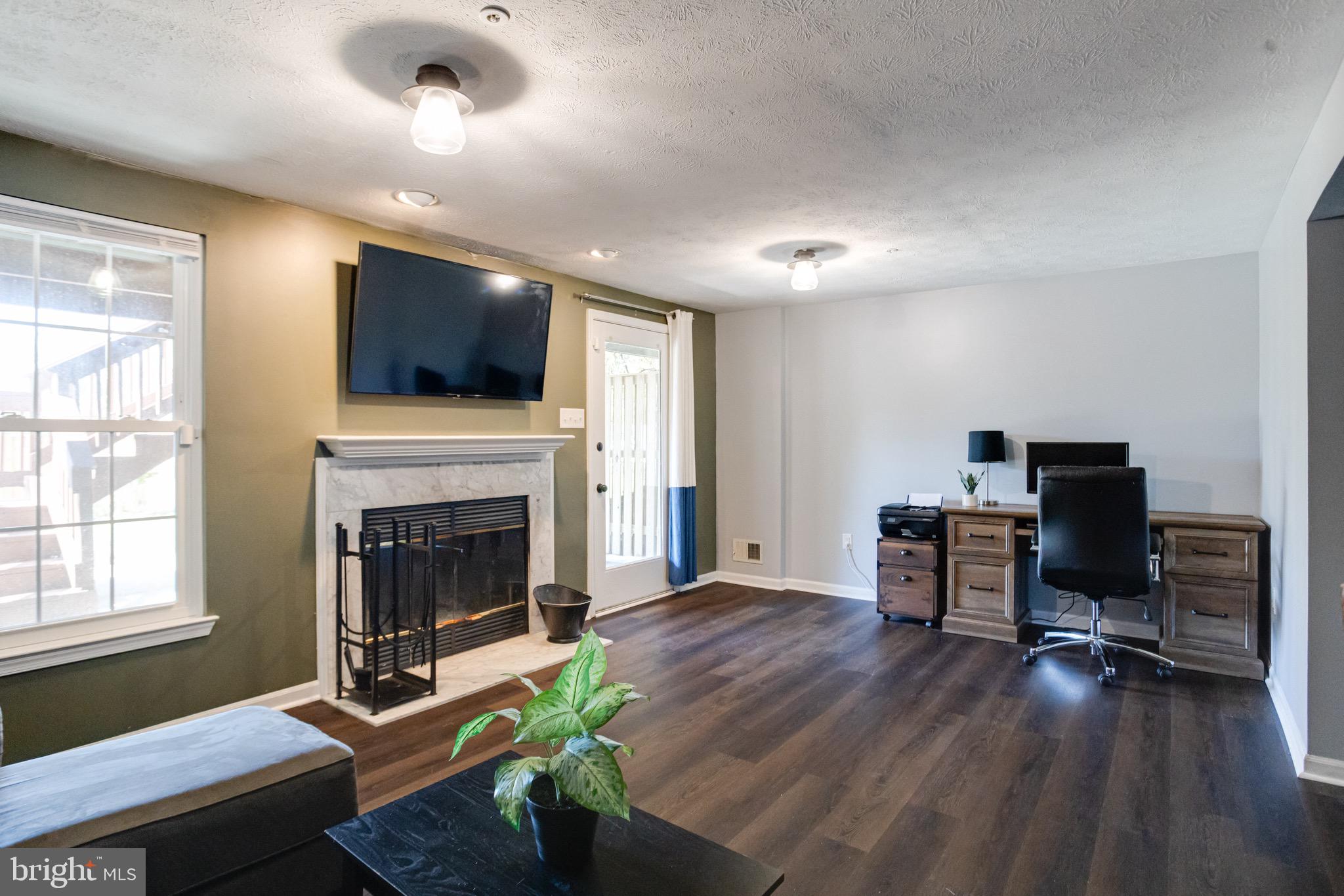 16 Sandview Court Baltimore, MD 21209 - Photo 42 of 58 a living room with furniture a flat screen tv and a fireplace
