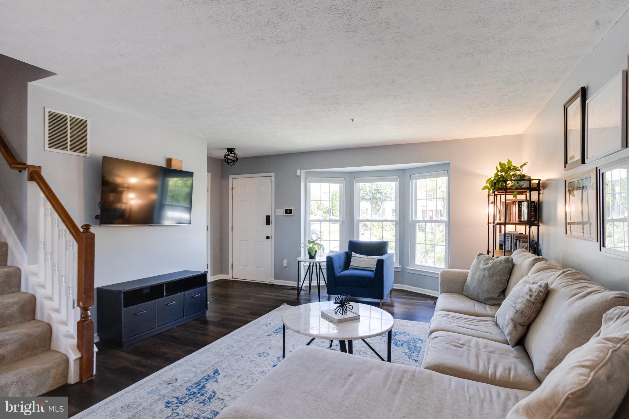 16 Sandview Court Baltimore, MD 21209 - Photo 6 of 58 a living room with furniture a flat screen tv and a floor to ceiling window