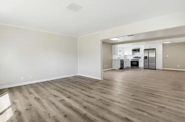 a view of a livingroom with wooden floor and a window