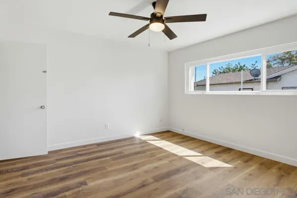 a view of a big room with wooden floor and windows