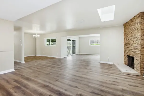 an empty room with wooden floor and fireplace