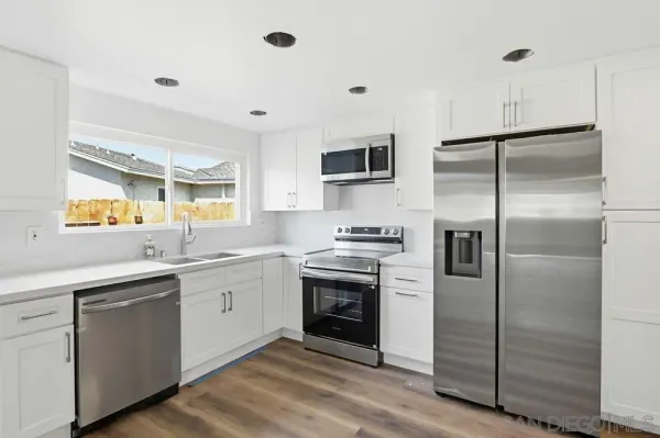 a kitchen with a sink stainless steel appliances and cabinets