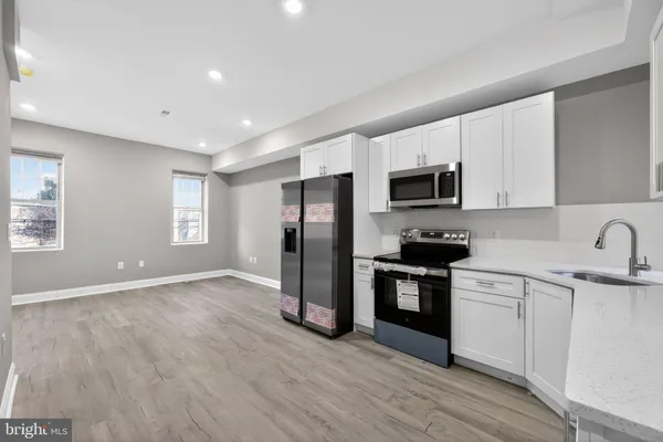 a kitchen with stainless steel appliances granite countertop a refrigerator microwave and sink