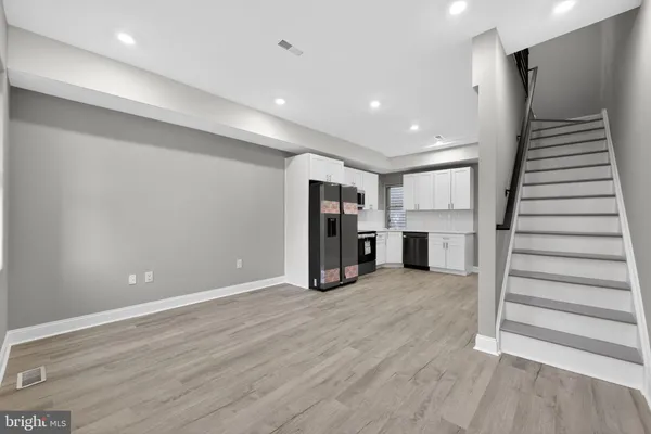 a view of empty room with wooden floor and stairs