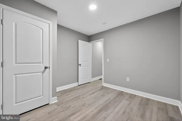 an empty room with wooden floor and closet